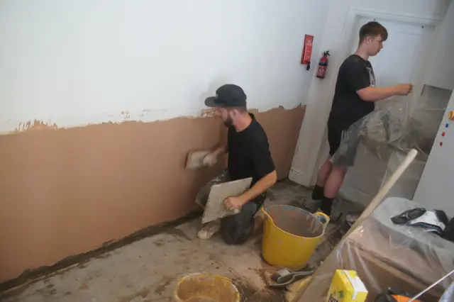 Two of the team replastering after treatment