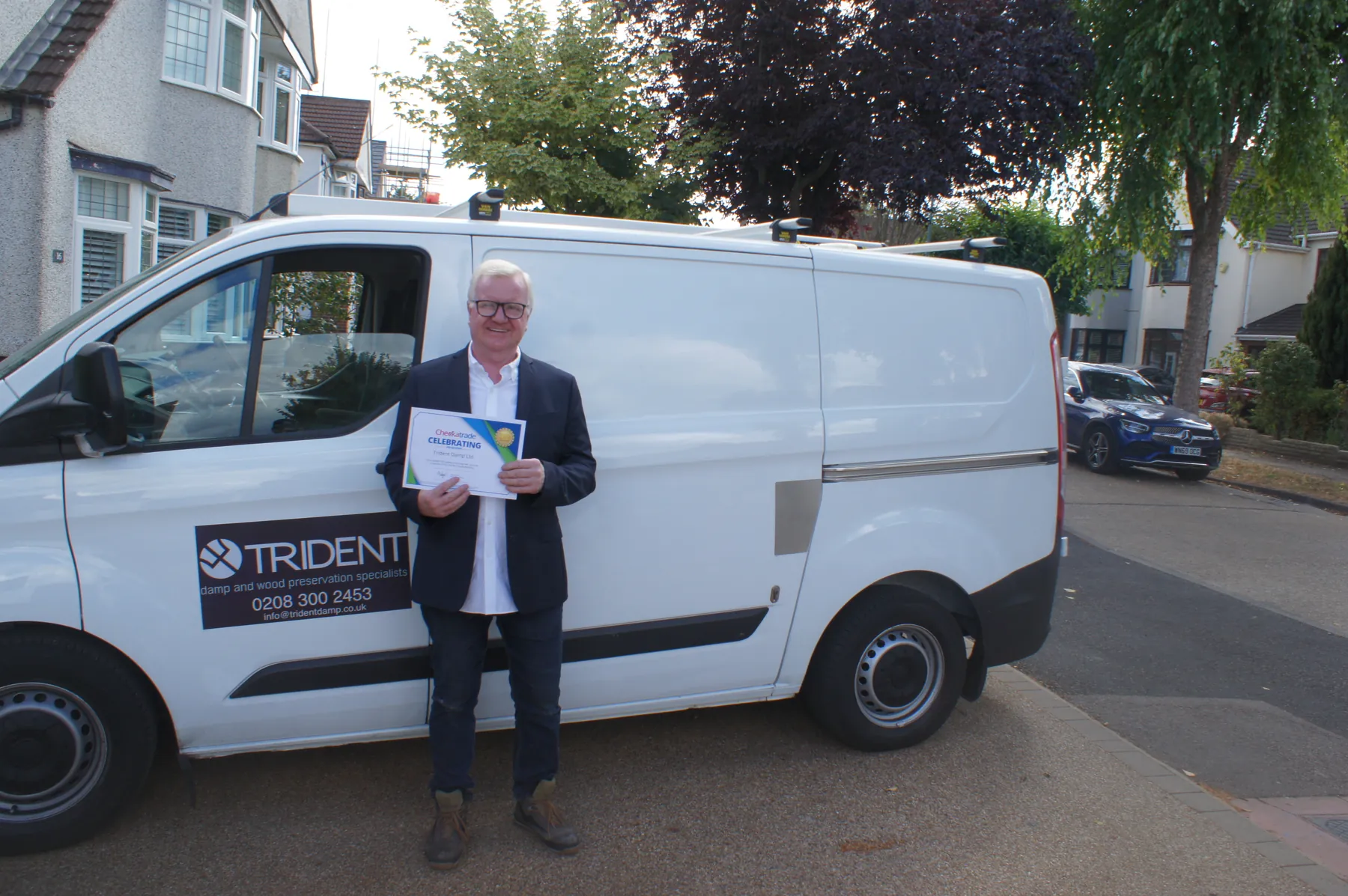 Joseph O'Regan of Trident Damp with the sign-written company van outside a client's home