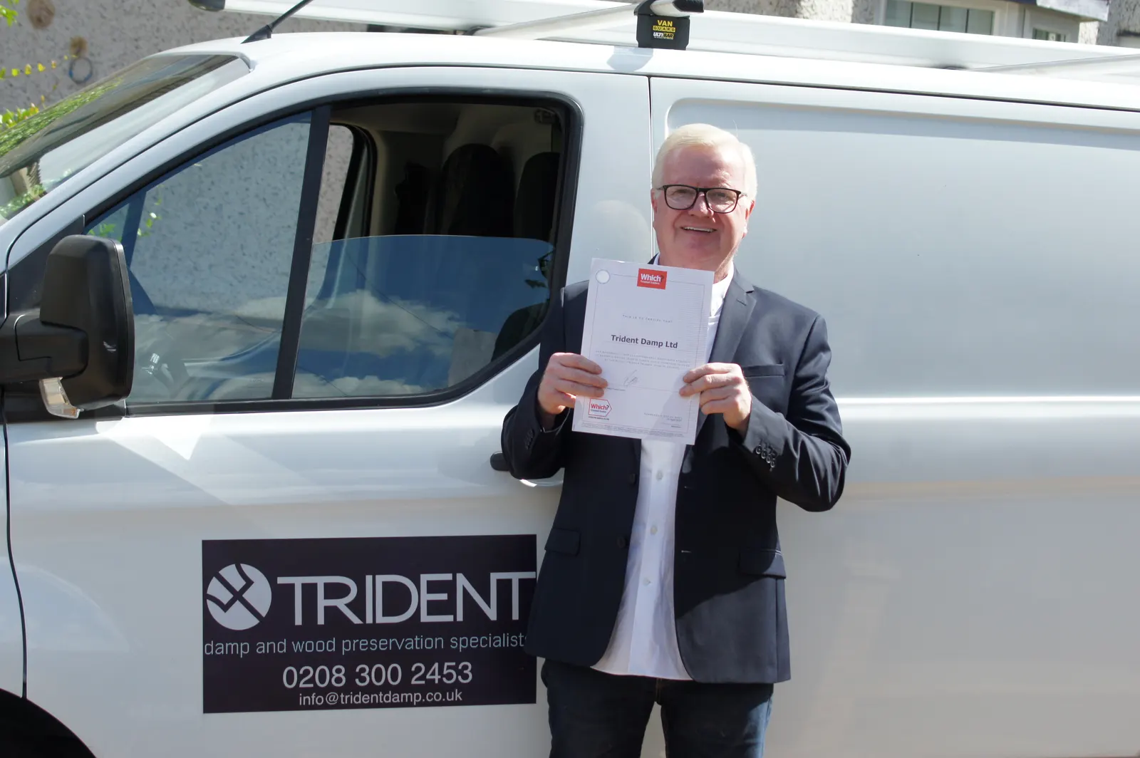 Joseph O'Regan holding the Which? Trusted Traders certificate beside the Trident van